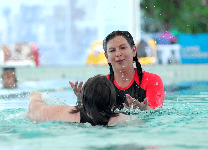 a participant swimming together with her support woker